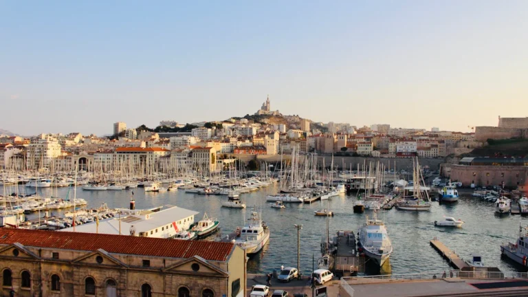 Vue panoramique sur le Vieux-Port de Marseille avec la basilique Notre-Dame de la Garde dominant la ville.