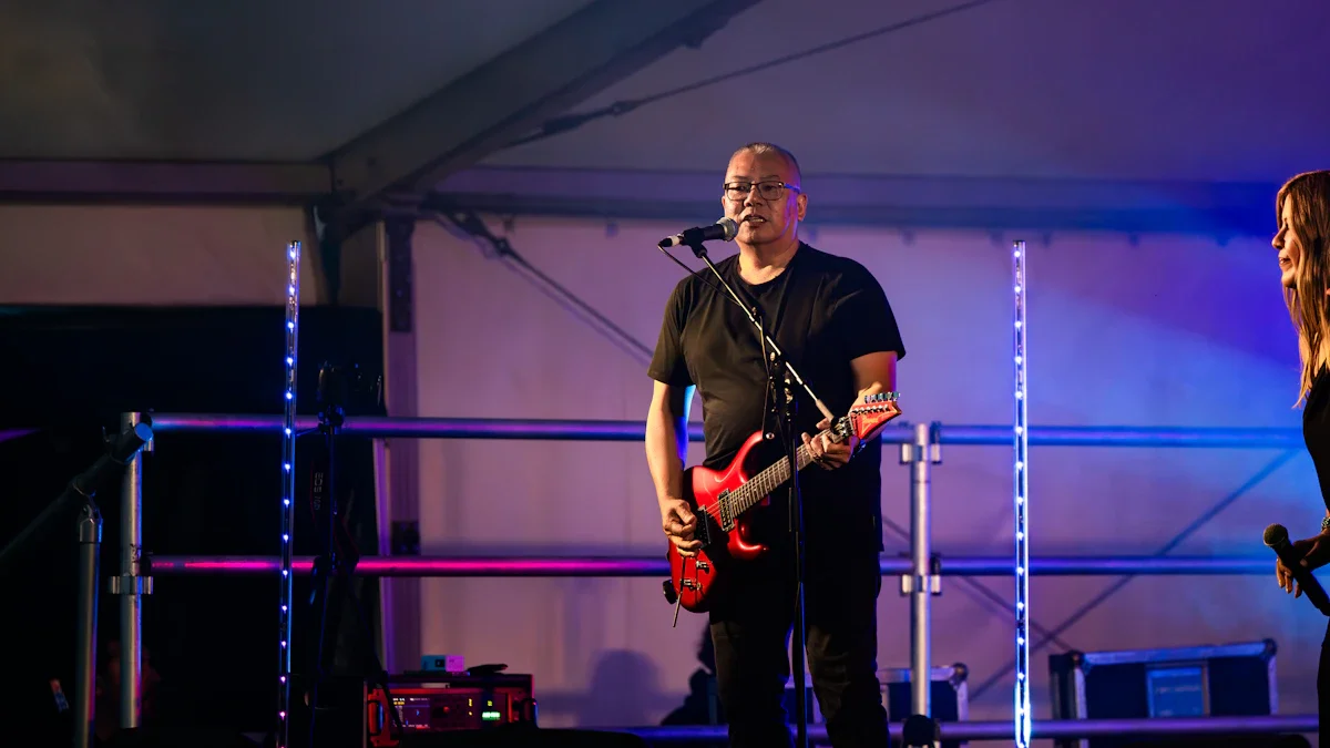 Un guitariste et chanteur de rock se produit sur une scène couverte lors de la fête de Célony à Aix-en-Provence.