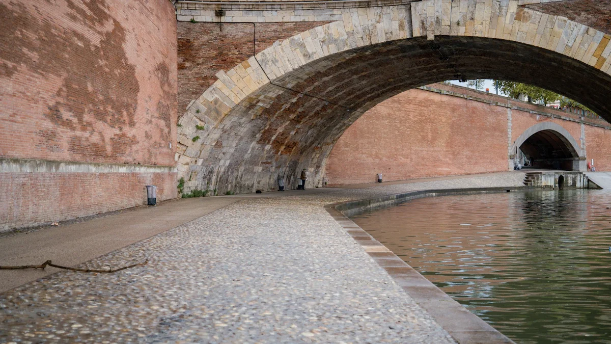 Entrée d'une ancienne galerie souterraine de captage d'eau avec une voûte en pierre à Aix-en-Provence.