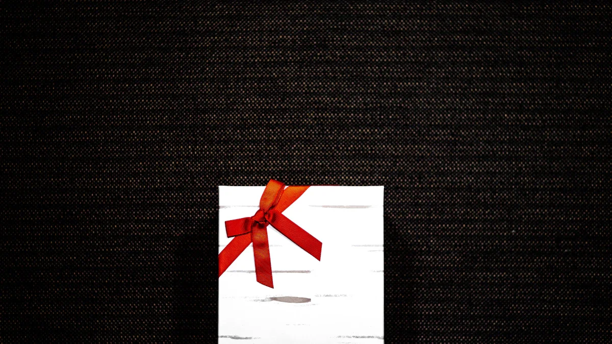 Une boîte cadeau blanche élégante ornée d'un ruban rouge vif sur un fond sombre texturé.