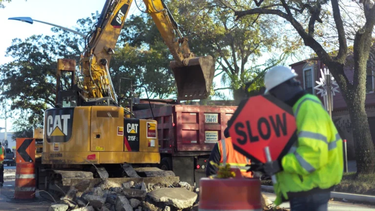 Pelleteuse de chantier et signalisation routière lors de travaux de voirie en ville.