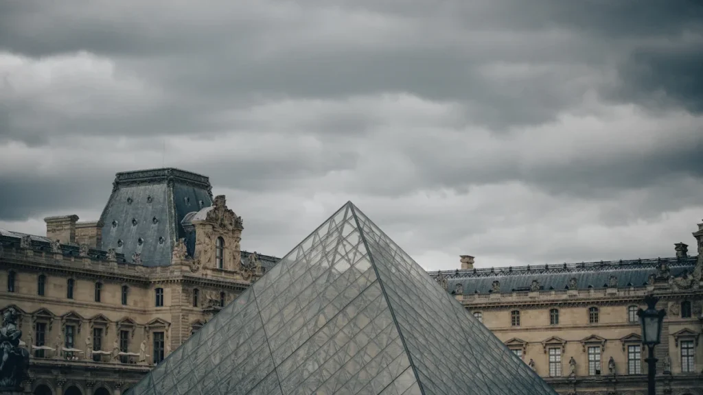La pyramide du Louvre à Paris, un exemple d'architecture urbaine française sous un ciel couvert.