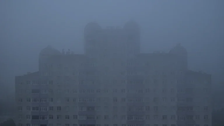 Façade d'un imposant immeuble de la résidence des Gémeaux à Montpellier émergeant d'une brume épaisse, évoquant une atmosphère de science-fiction.
