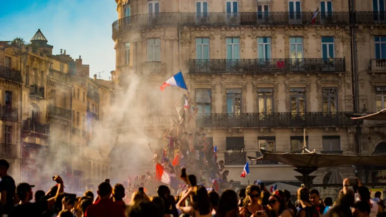 Une foule en liesse avec des drapeaux français célèbre sur la place de la Comédie à Montpellier.