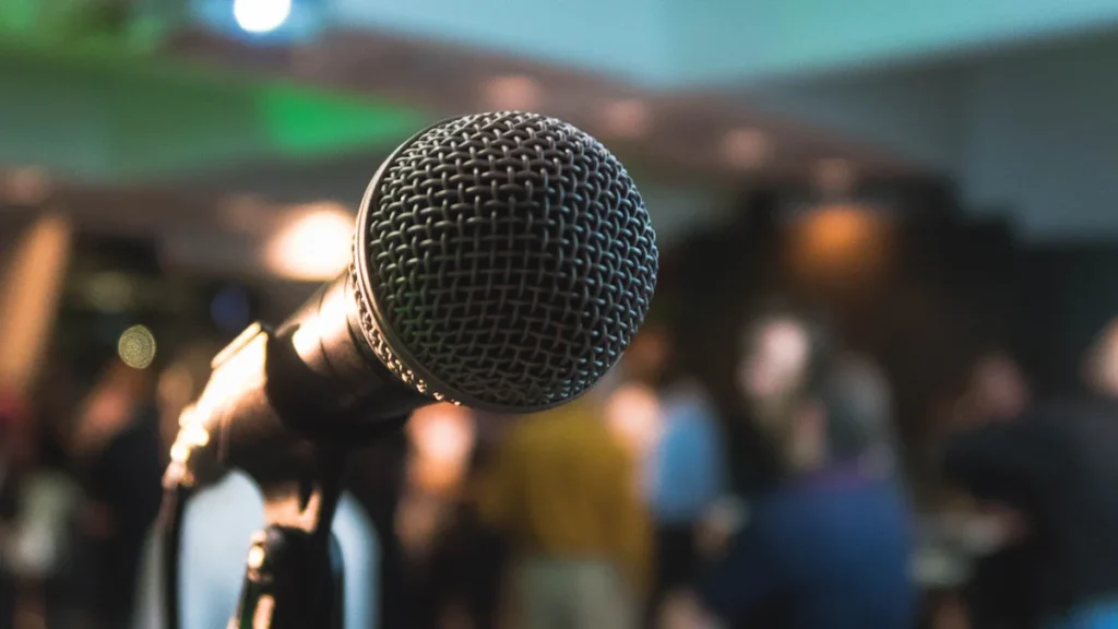 Un microphone professionnel en gros plan devant une salle de réunion floue pour les débats.