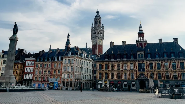 Vue panoramique de la Grand Place de Lille avec ses bâtiments historiques et son beffroi emblématique.