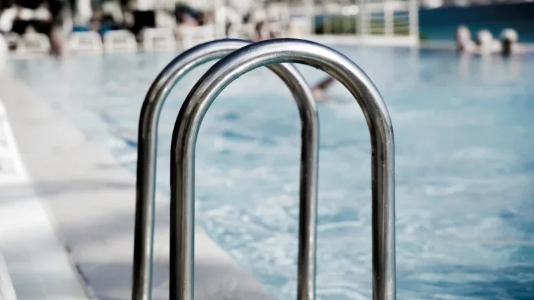 Gros plan sur l'échelle métallique d'une piscine publique moderne.