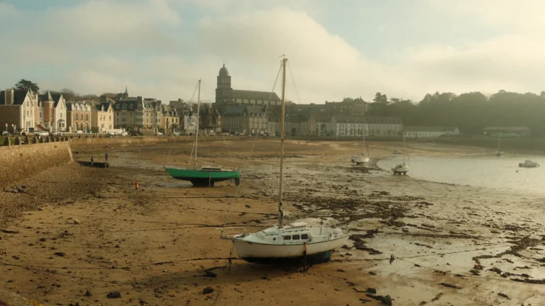 Voiliers échoués sur le sable à marée basse devant les bâtiments de Brest.