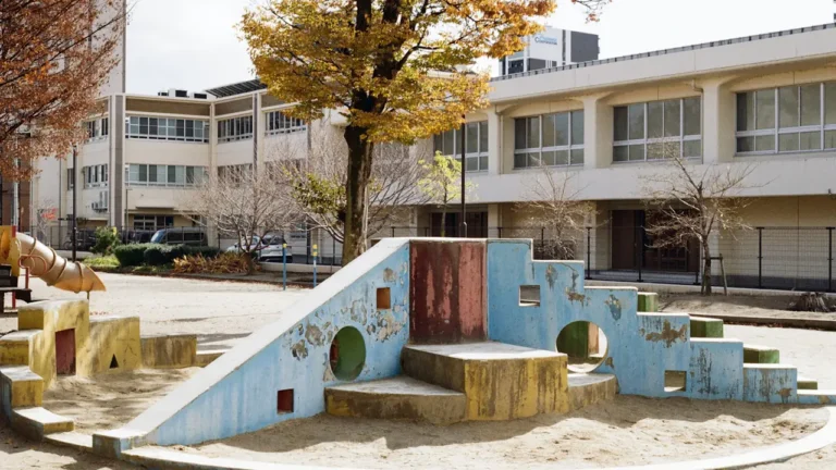 Structure de jeu colorée dans une cour d'école urbaine ensoleillée.