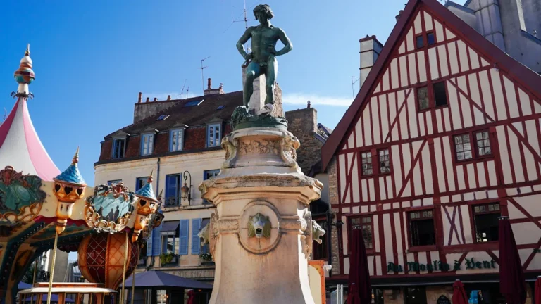 Statue de bronze au centre de la place François-Rude à Dijon avec manège
