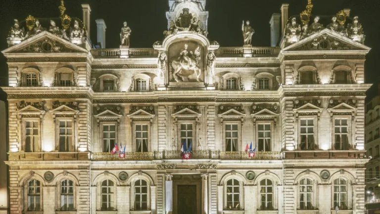 Façade illuminée de l'Hôtel de Ville de Lyon, symbole de l'administration municipale lyonnaise.