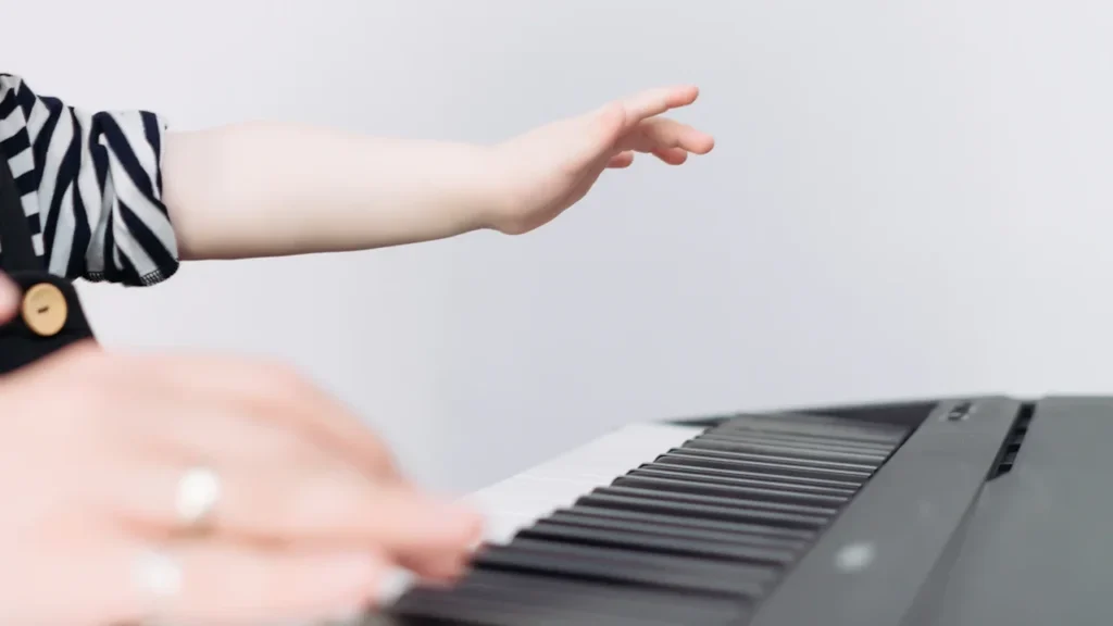 Mains d'un enfant apprenant à jouer du piano au conservatoire de musique