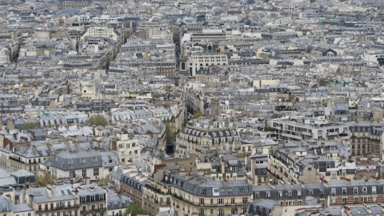 Vue aérienne panoramique des toits et immeubles d'une ville française dense.