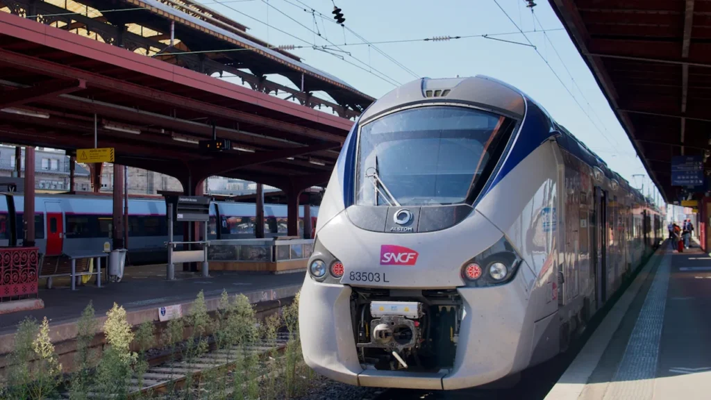 Un train SNCF à l'arrêt sur le quai d'une gare en France.