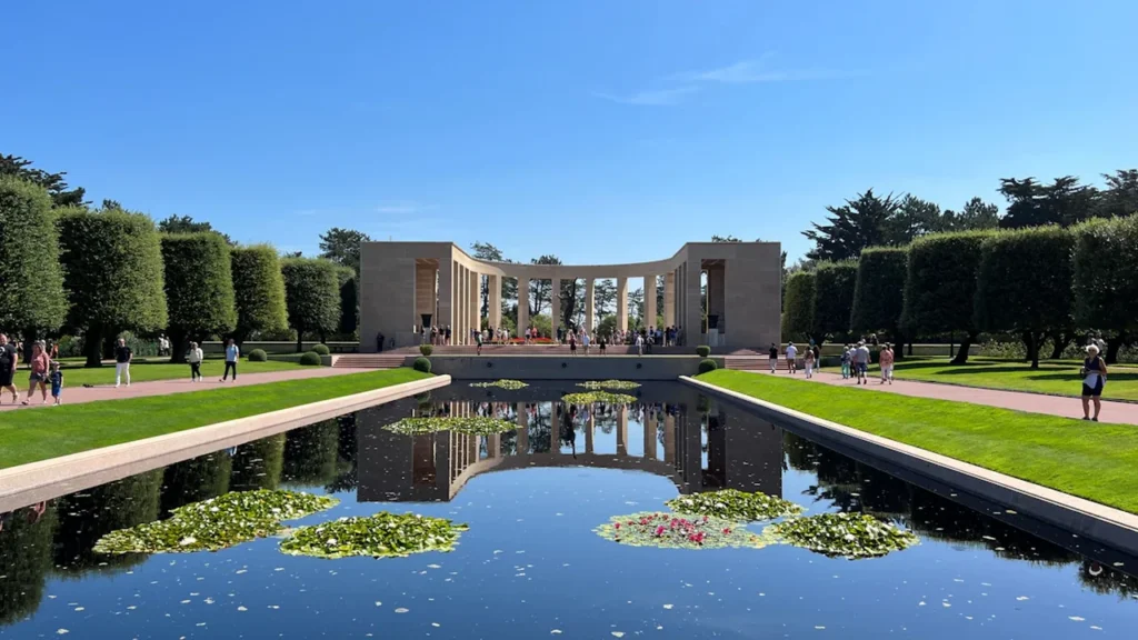 Le bassin paisible et le monument commémoratif dans un jardin de Normandie.