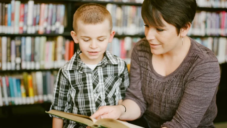 Une mère lit un livre avec son jeune fils dans une bibliothèque publique.