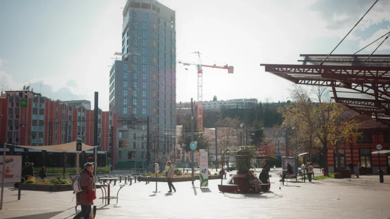 Vue urbaine de la place de la gare à Saint-Étienne sous un ciel dégagé.