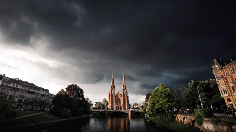 Ciel sombre et menaçant au-dessus d'une cathédrale au bord d'une rivière