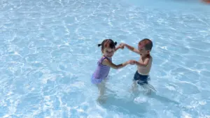 Deux jeunes enfants jouant joyeusement dans l'eau d'une piscine claire.
