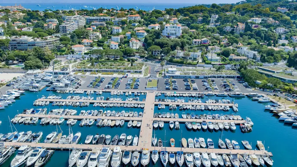 Vue aérienne d'un port de plaisance rempli de nombreux bateaux le long de la côte.