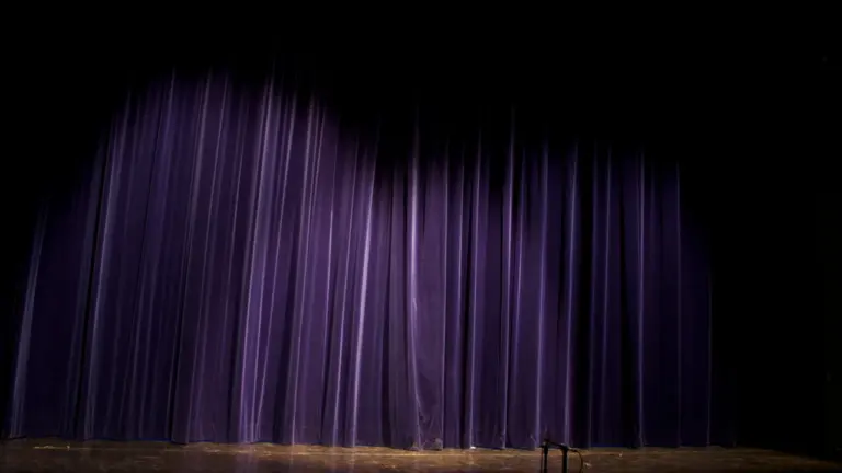 Rideau de scène sombre et fermé dans un théâtre de France.