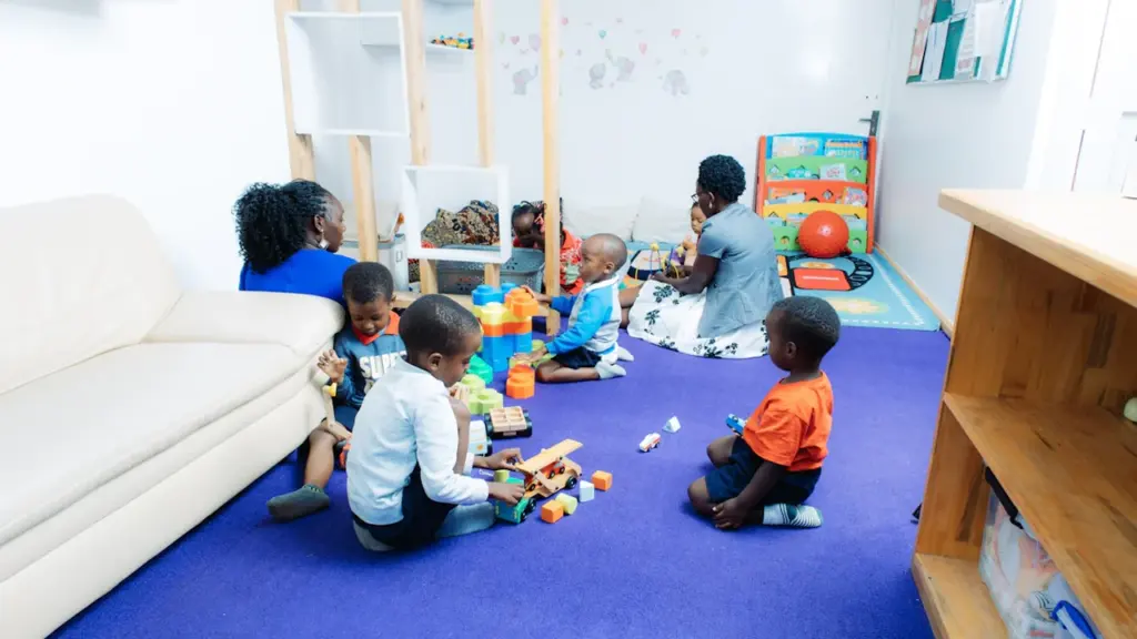 Enfants en train de jouer ensemble dans une salle d'activités lumineuse et accueillante.