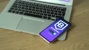 Un smartphone posé sur un ordinateur portable pour illustrer l'aide numérique individuelle.