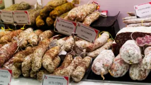 Un étal de marché parisien proposant une large variété de saucissons artisanaux savoureux.