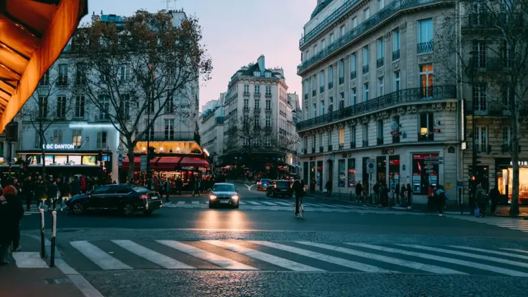 Une rue française avec un passage piéton et une voiture noire garée.