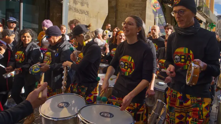 Un groupe de musiciens jouant des percussions dans une rue animée de Tours.